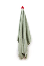 Charger l'image dans la galerie, sage green towel hanging on red wall hook