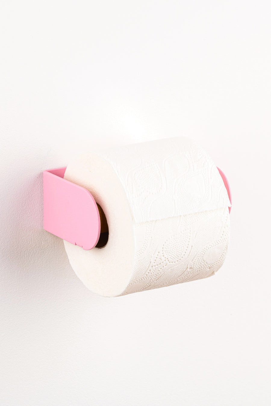 Pink toilet paper holder in sleek minimalist design. Made from powder coated stainless steel and available in multiple colours