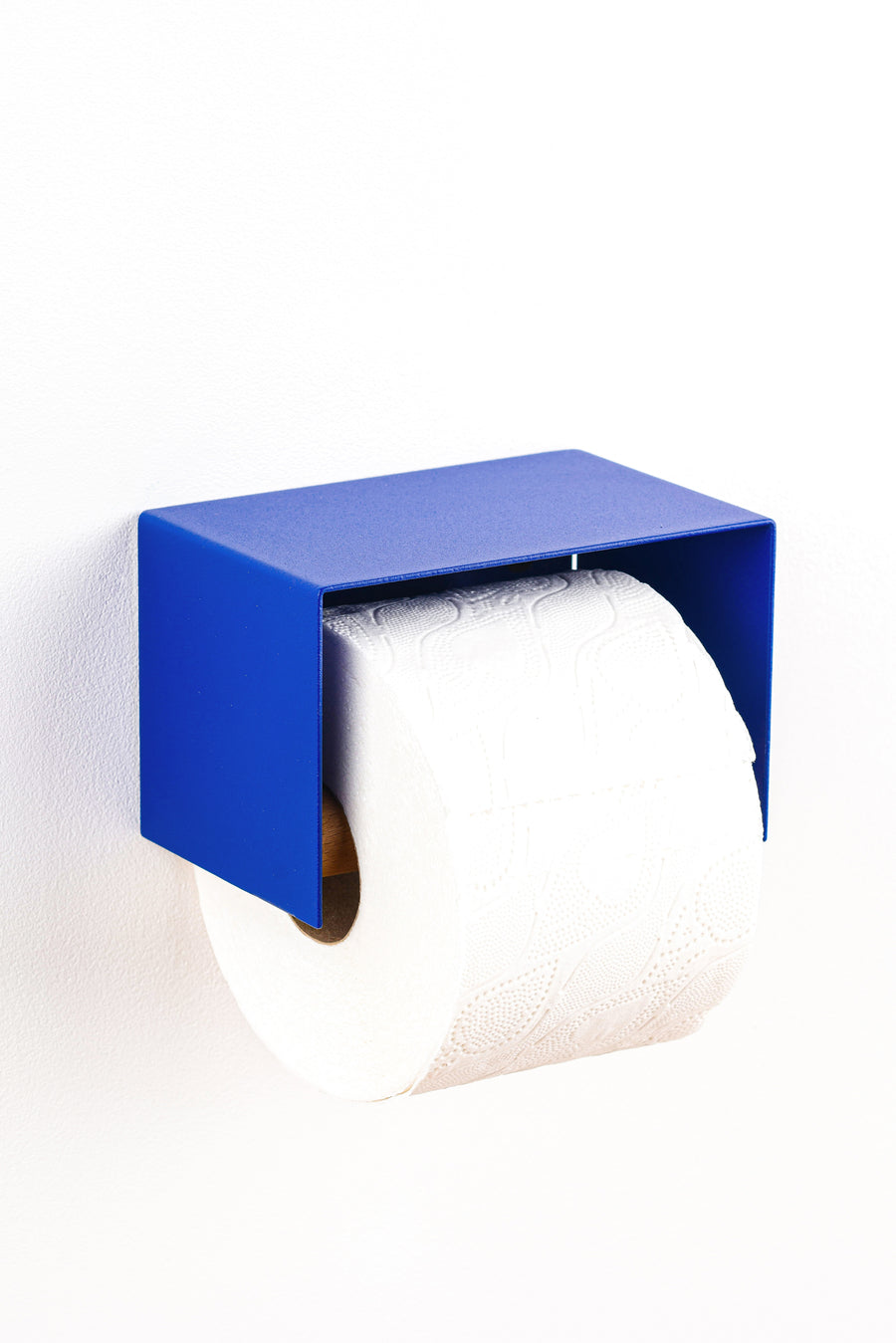 blue toilet paper holder in nice design where you can put things on top like a phone or candle or some small accessories. 