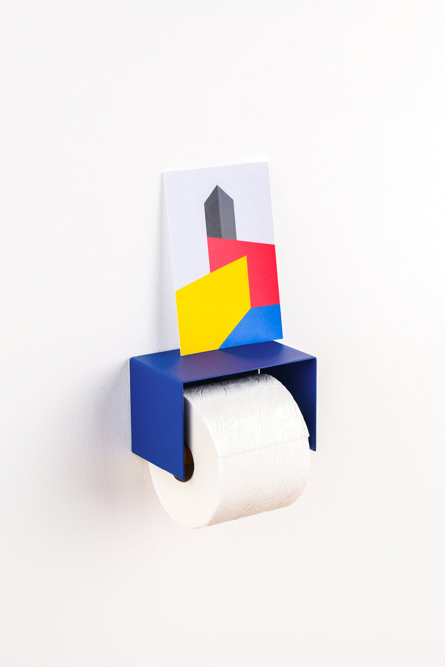 blue toilet paper holder in nice design where you can put things on top like a phone or candle or some small accessories. Here with a bauhaus post card