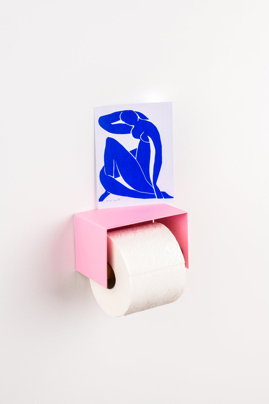 pink toilet paper holder in nice design where you can put things on top like a phone or candle or some small accessories.  Here shown with a matisse post card