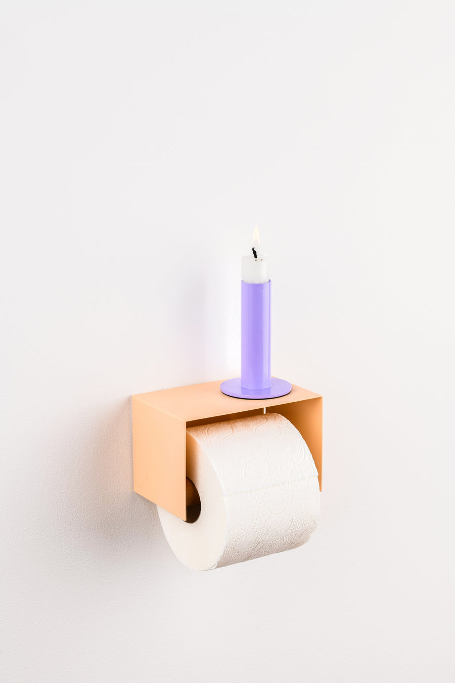 salmon pink toilet paper holder in nice design where you can put things on top like a phone or candle or some small accessories.  Here with a purple candle on top