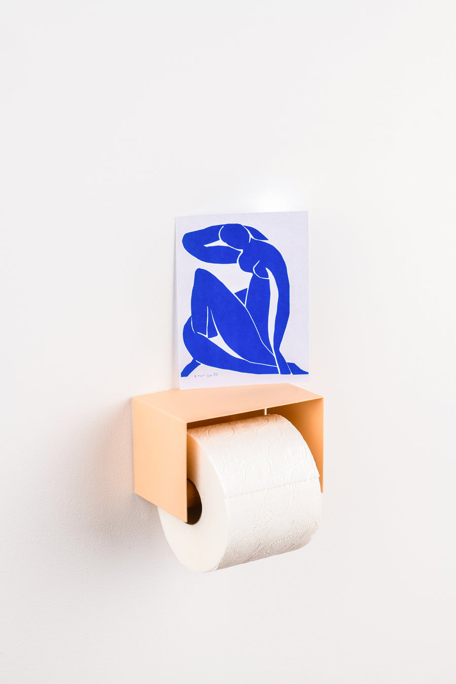 salmon pink toilet paper holder in nice design where you can put things on top like a phone or candle or some small accessories.  Here with a blue matisse post card
