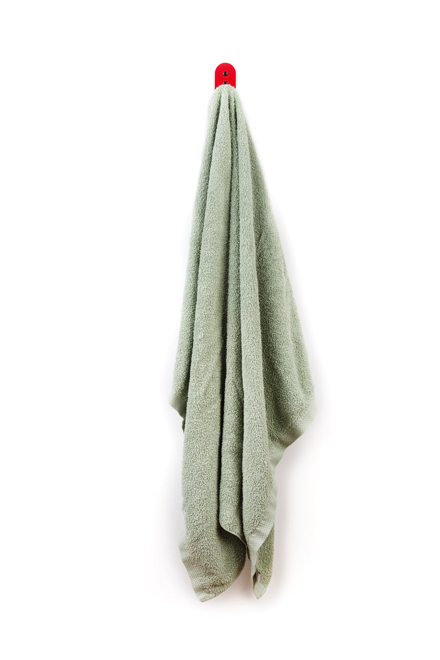 sage green towel hanging on red wall hook 