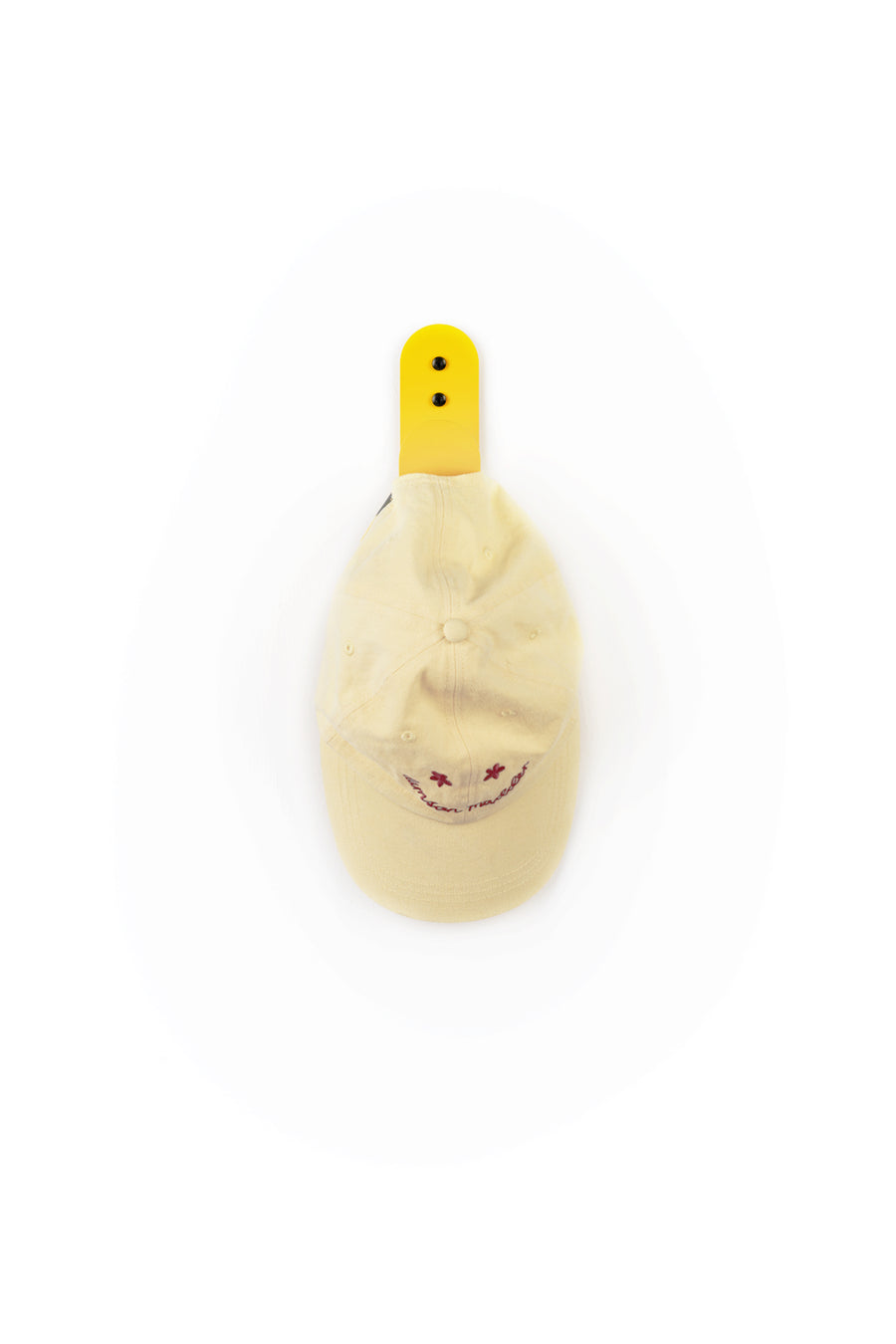 yellow cap hanging on large yellow wall hook