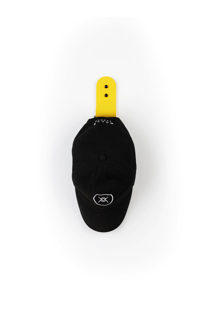 yellow wall hook with black malle london cap