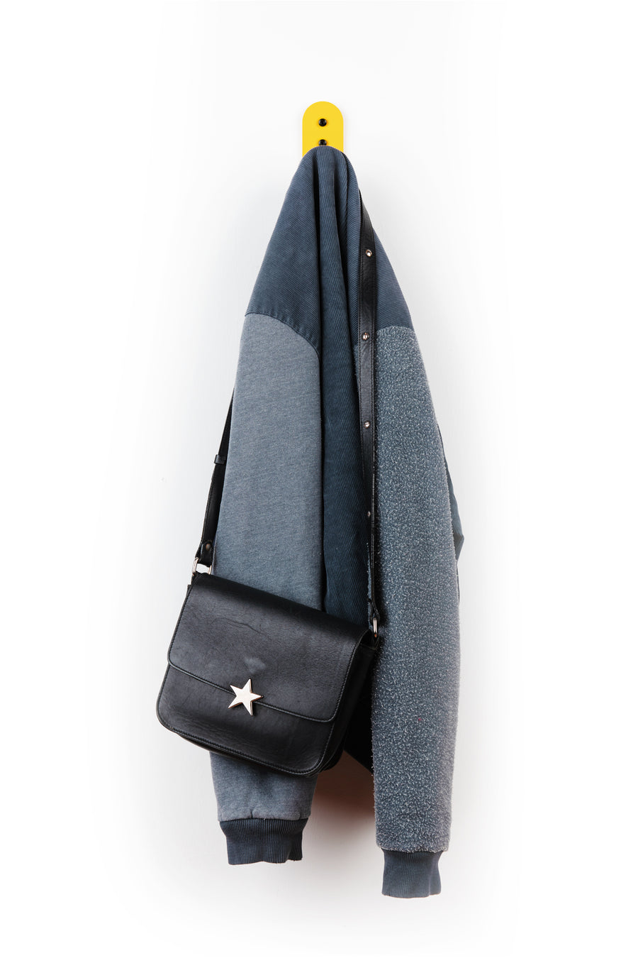 yellow wall hook with blue jacket and deep blue purse