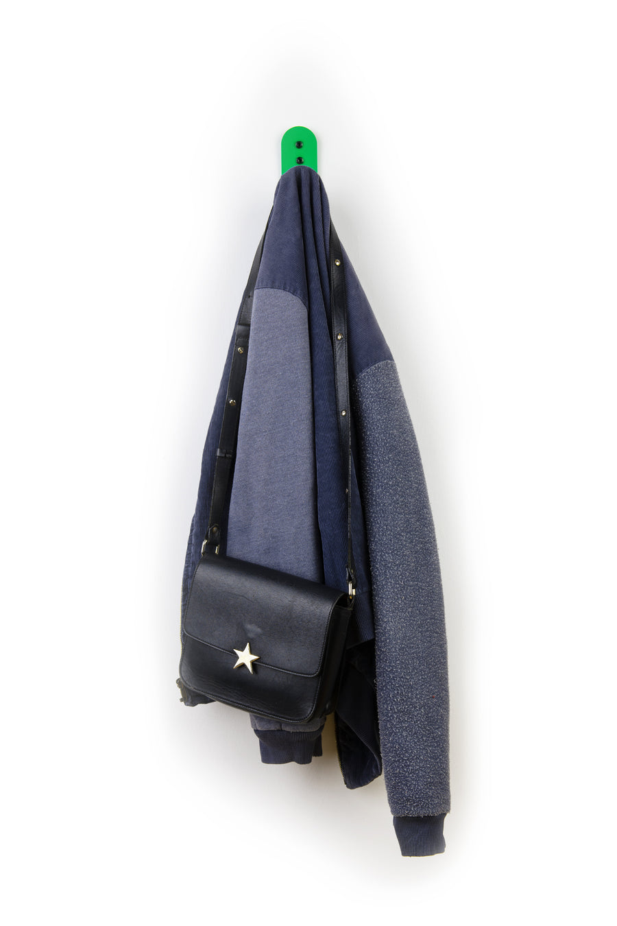 green wall hook with blue jacket and purse