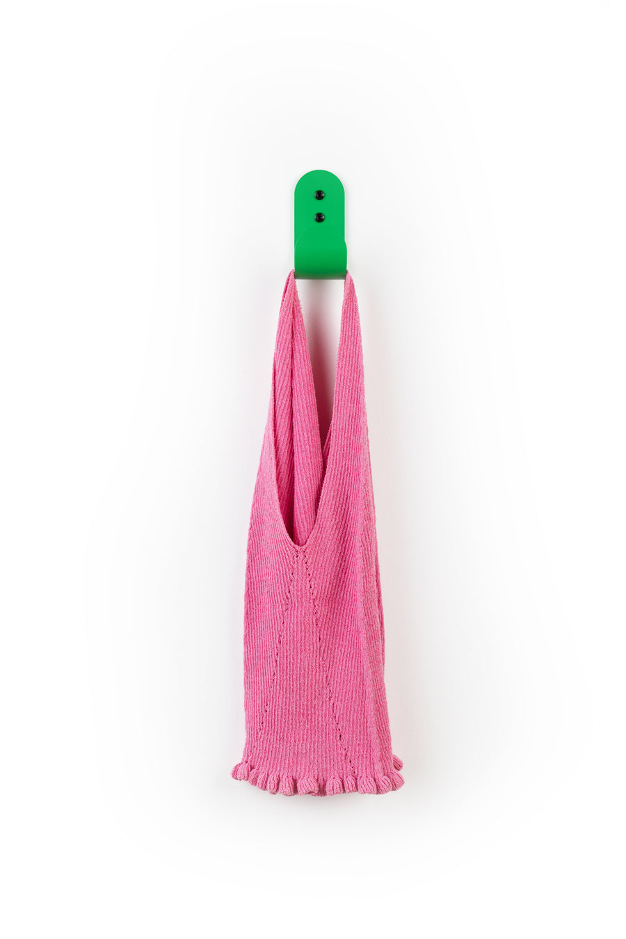 green wall hook with pink shirt