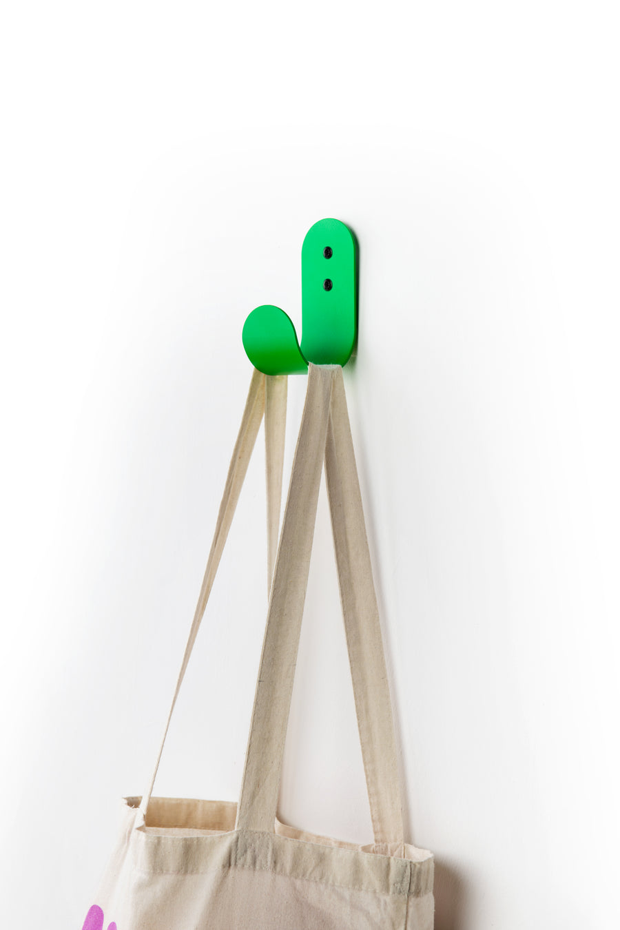 Green wall hook with white tote bag