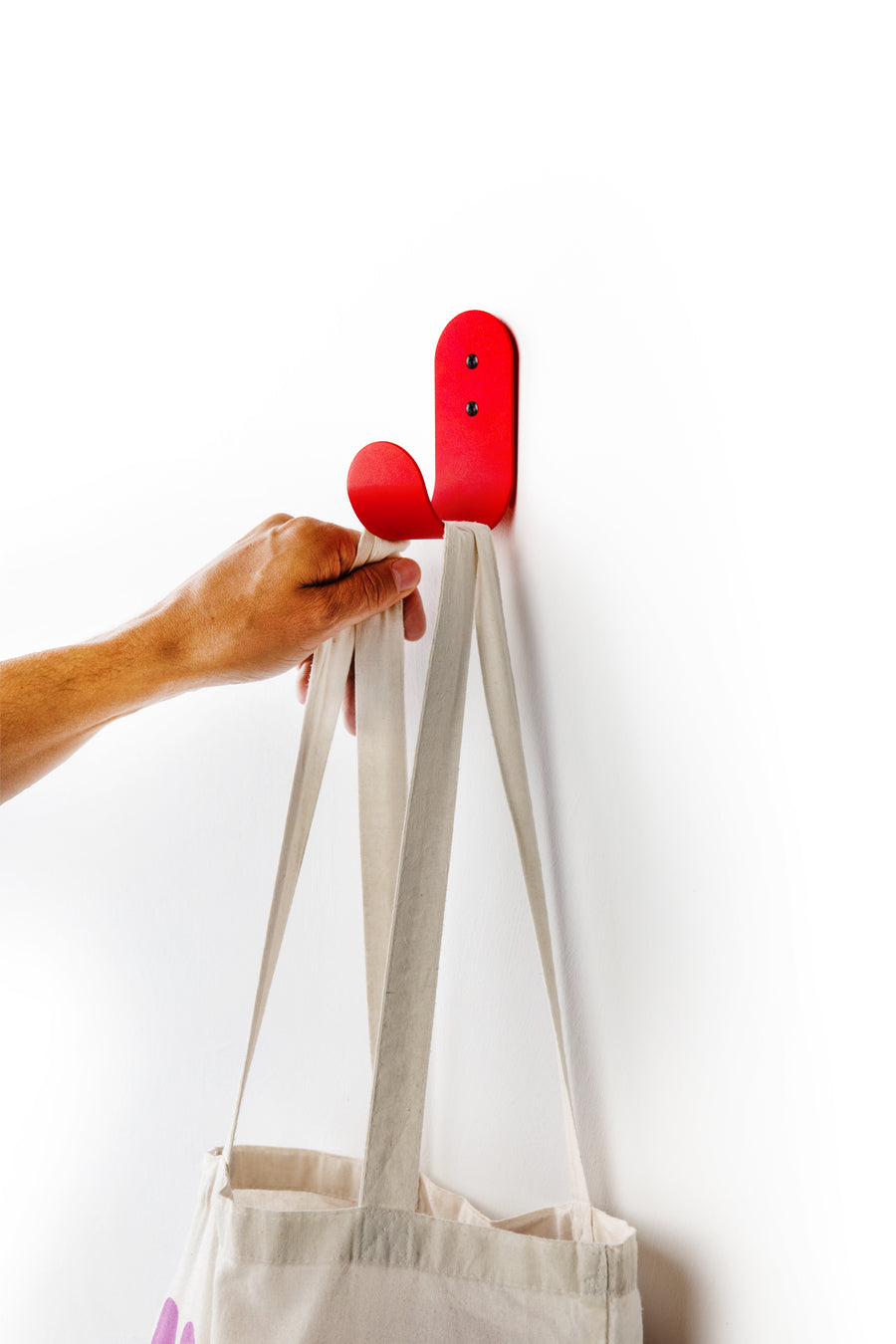 red wall hook with white tote bag